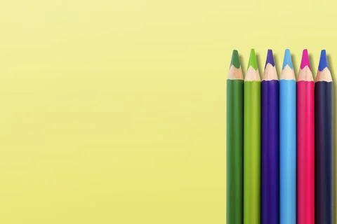 Colored pencils on a yellow background Stock Photos