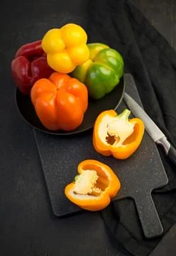 Colored peppers on black background Stock Photos
