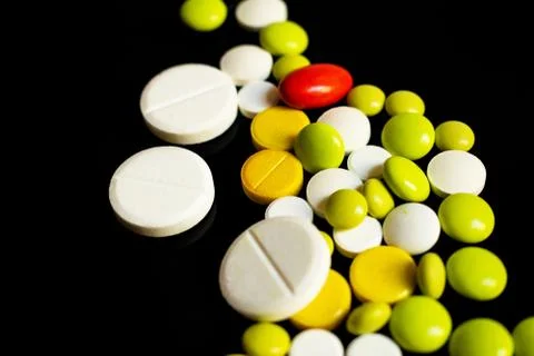 Colored pills on a black background Stock Photos