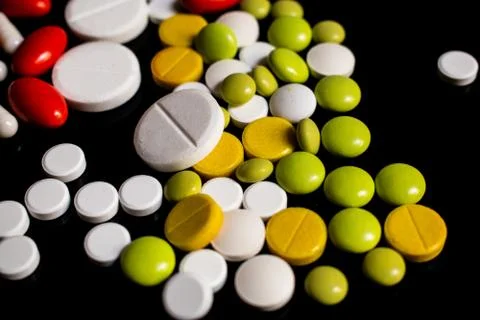Colored pills on a black background Stock Photos