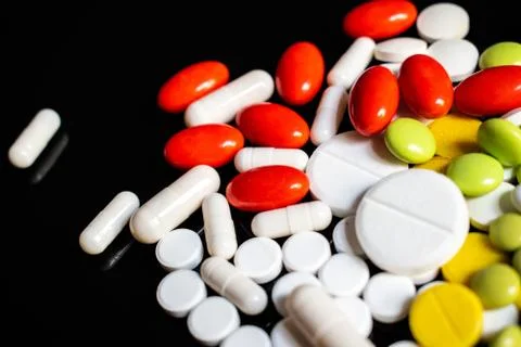 Colored pills on a black background Stock Photos