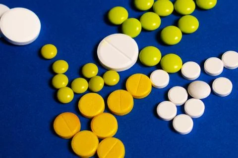 Colored pills on a blue background Stock Photos