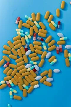 Colored pills on blue background. Stock Photos