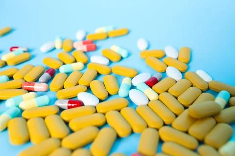 Colored pills on blue background. Stock Photos
