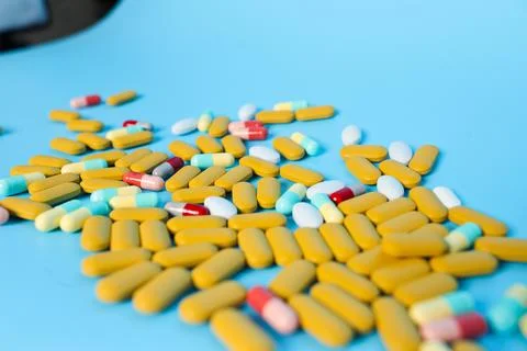Colored pills on blue background. Stock Photos