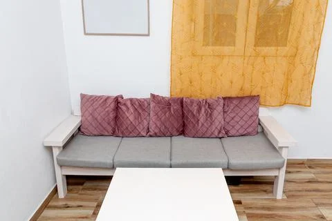Colored pink soft pillows on sofa, cozy interior of hotel apartment living ro Stock-Fotos