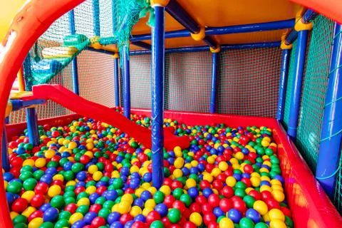 Colored plastic balls in pool of game room. Swimming pool for fun and jumping in Stock Photos