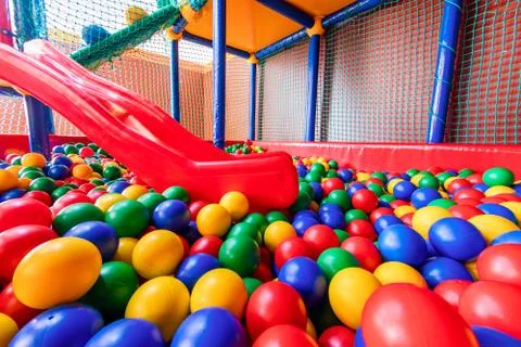 Colored plastic balls in pool of game room. Swimming pool for fun and jumping in Stock Photos