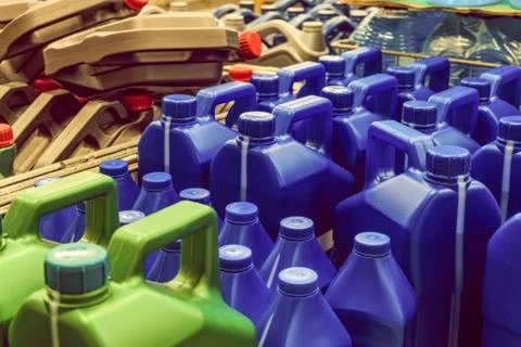 Colored plastic cans with engine oil. Canisters placed on a pallet. Stock Photos