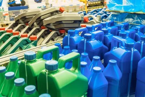 Colored plastic cans with engine oil. Canisters placed on a pallet. Stock Photos