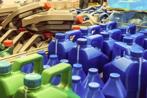 Colored plastic cans with engine oil. Canisters placed on a pallet. Stock Photos