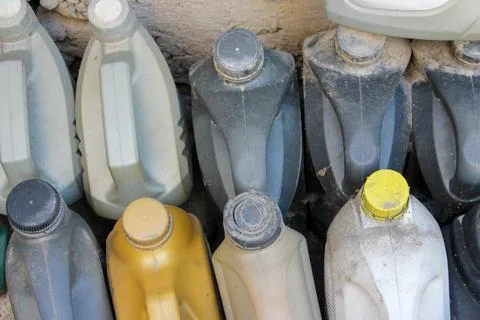 Colored plastic cans with engine oil. Rows of canisters placed on the ground Stock Photos