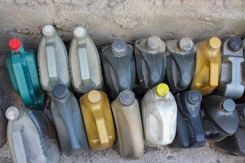 Colored plastic cans with engine oil. Rows of canisters placed on the ground Stock Photos