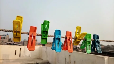 Colored plastic clothes pins or clothes pegs for house hanging on rope  Video stock 306340129