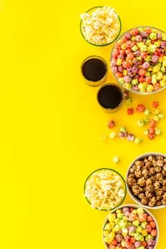 Colored popcorn in box on yellow background top view copy space Stock Photos