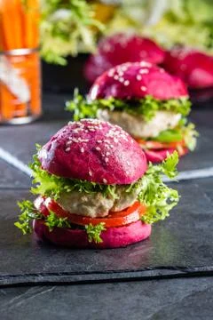 Colored purple beetroot buns and chicken burgers. Stock Photos