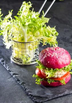 Colored purple beetroot buns and chicken burgers. Stock Photos