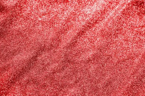 Colored red shiny fabric texture with folds. Surface background colors of the Stock Photos