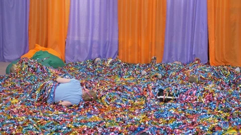 Colored ribbons fly in different directions. Children climb out of the colored s Stock Footage 129187308