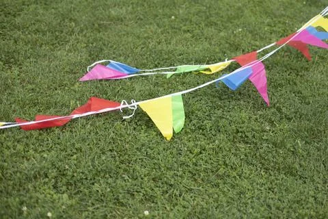 Colored ribbons on grass. Colored flags on green grass. Details of game in .. Stock Photos