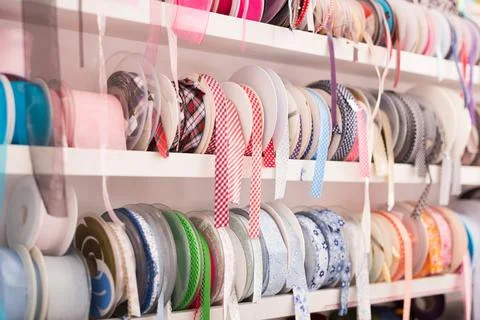 Colored ribbons on needlework store shelves Stock Photos