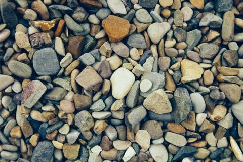 Colored river stone as a texture. Abstract background texture. Top view. Stock Photos