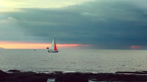 Colored sailing boat at sunset going to a storm Stock Footage 58670875