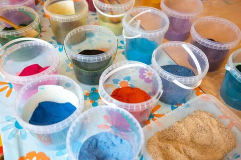 Colored sand in plastic containers, perfect for art and crafts Stock Photos