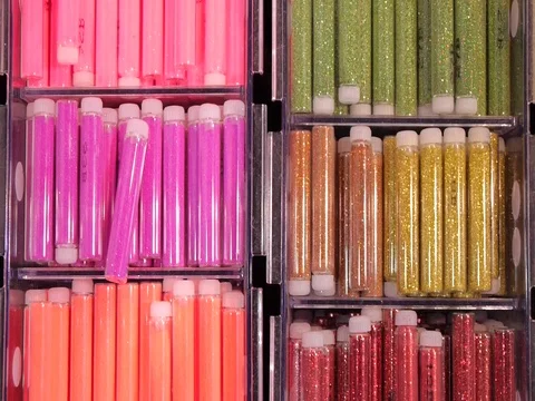 Colored sequinsin tubes for makeup. Shiny glitter on makeup. Stock Footage 73397759