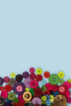 Colored sewing buttons composition on green pastel background. Flat lay with  Stock Photos