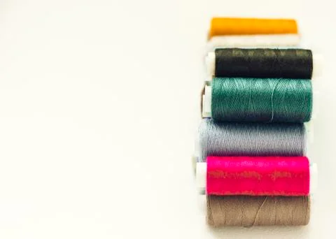 Colored sewing thread coils on white background with copy space for text. Stock Photos