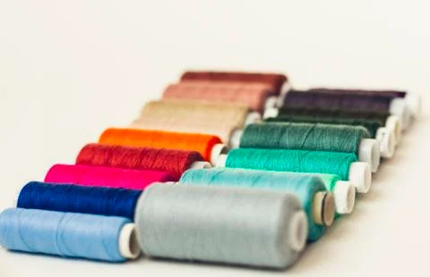 Colored sewing thread coils on white background with copy space for text. Stock Photos