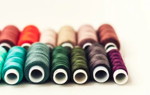 Colored sewing thread coils on white background with copy space for text. Foto stock
