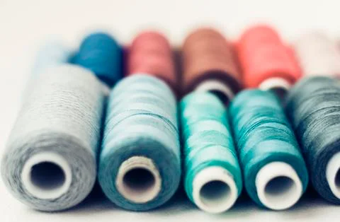 Colored sewing thread coils on white background with copy space for text. Stock Photos