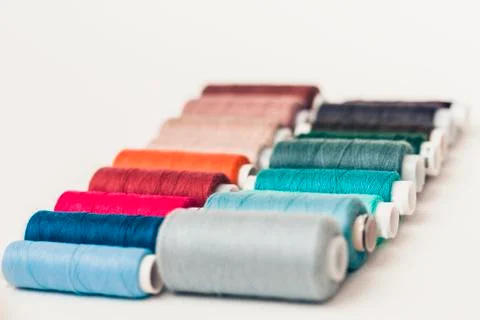 Colored sewing thread coils on white background with copy space for text. Stock Photos