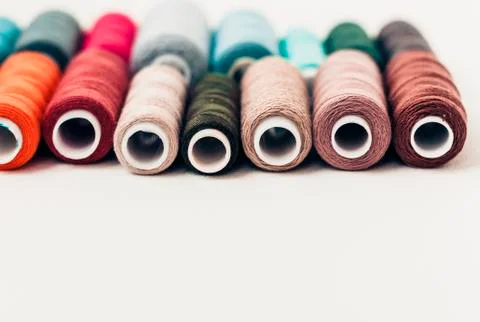 Colored sewing thread coils on white background with copy space for text. Stock Photos