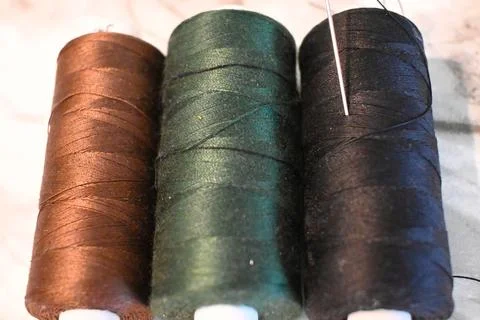 Colored sewing threads with needle Stock Photos