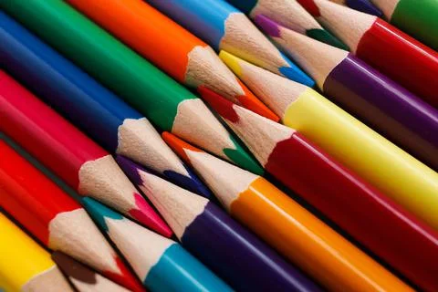 Colored sharpened pencils lie in a row close-up. Solid abstract background of Fotos Stock