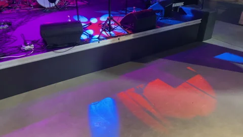 Colored show lights shine at a stage, ready for a band to perform their show. Stock Footage 200252897