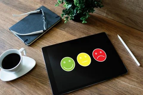 Colored smiles. Customer satisfaction control on device screen. Service and Stock-Fotos