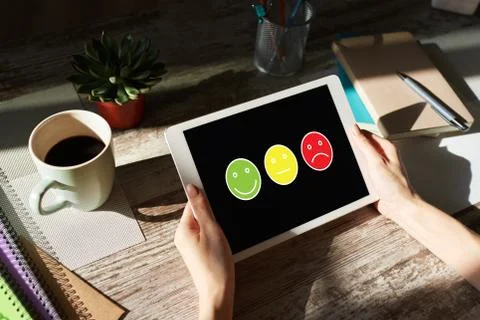 Colored smiles. Customer satisfaction control on device screen. Service and Stock-Fotos