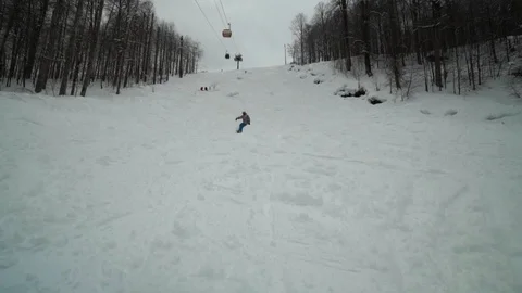 Colored snowboarder rides down the hill outs the ski track. Snowboarder Video stock 102291979