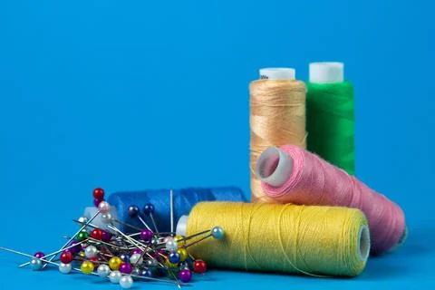 Colored spools of thread on a blue background. Stock Photos