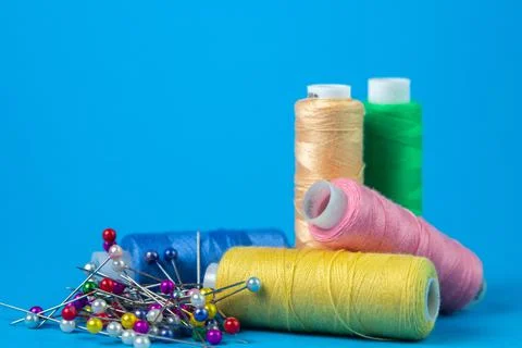 Colored spools of thread on a blue background. Stock Photos
