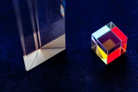 Colored square crystal with a rainbow on a substrate in close-up Stock Photos