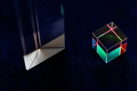 Colored square crystal with a rainbow on a substrate in close-up Stock Photos