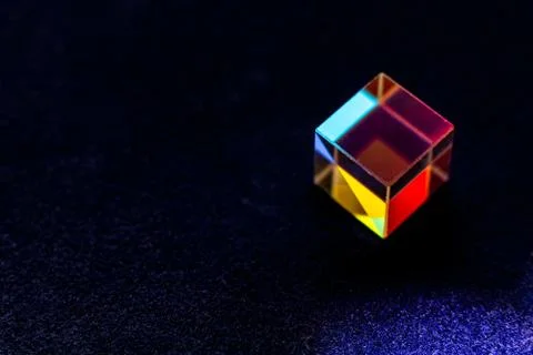 Colored square crystal with a rainbow on a substrate in close-up Stock Photos