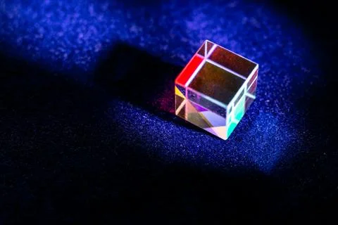 Colored square crystal with a rainbow on a substrate in close-up Stock Photos