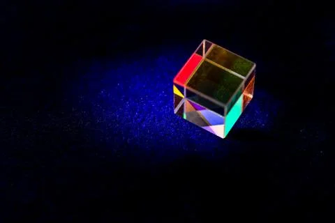 Colored square crystal with a rainbow on a substrate in close-up Stock Photos