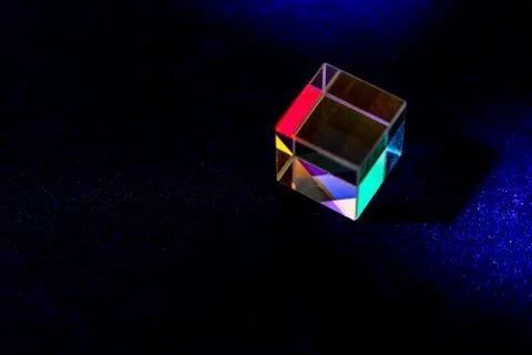 Colored square crystal with a rainbow on a substrate in close-up Stock Photos